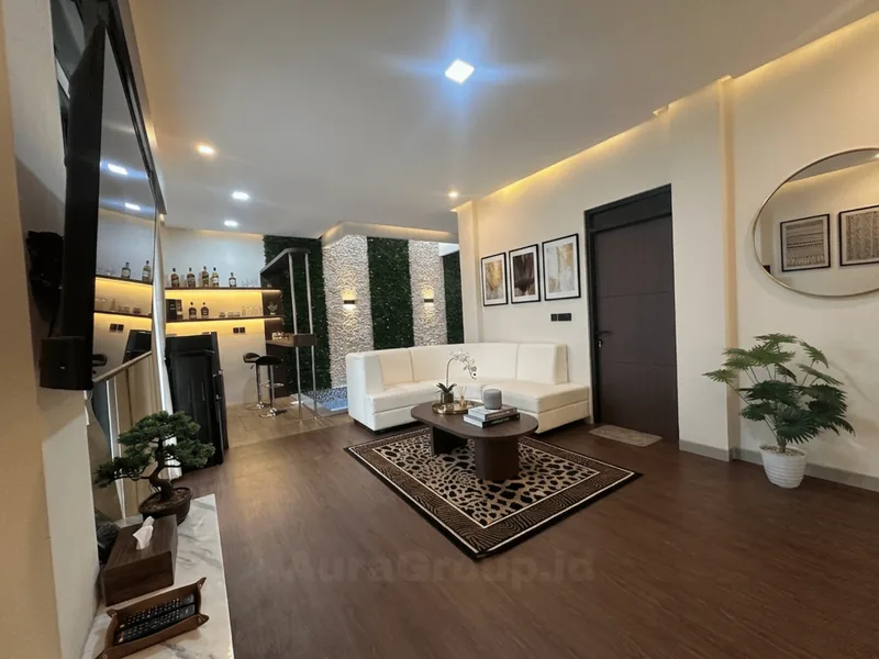 Ruang keluarga villa The Village Resort Batu yang dikelola InapStay: sofa putih, meja kopi dan pencahayaan hangat